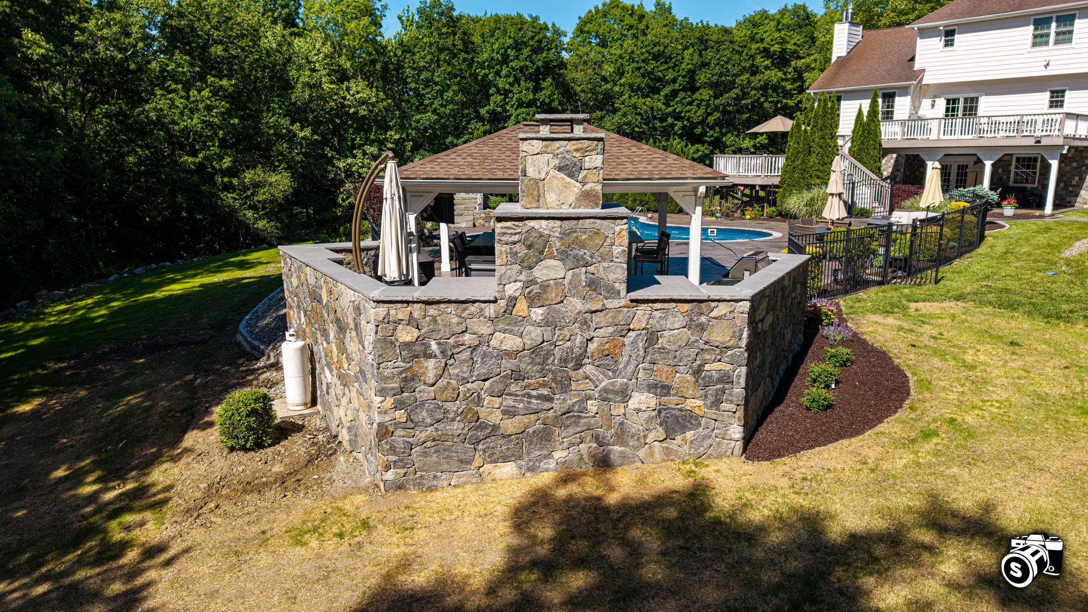 Stone outdoor kitchen and fireplace — aerial
