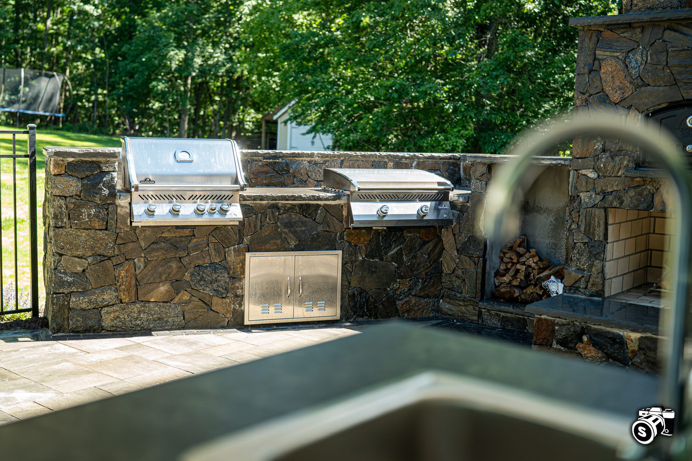 Stone outdoor kitchen with two built-in grills