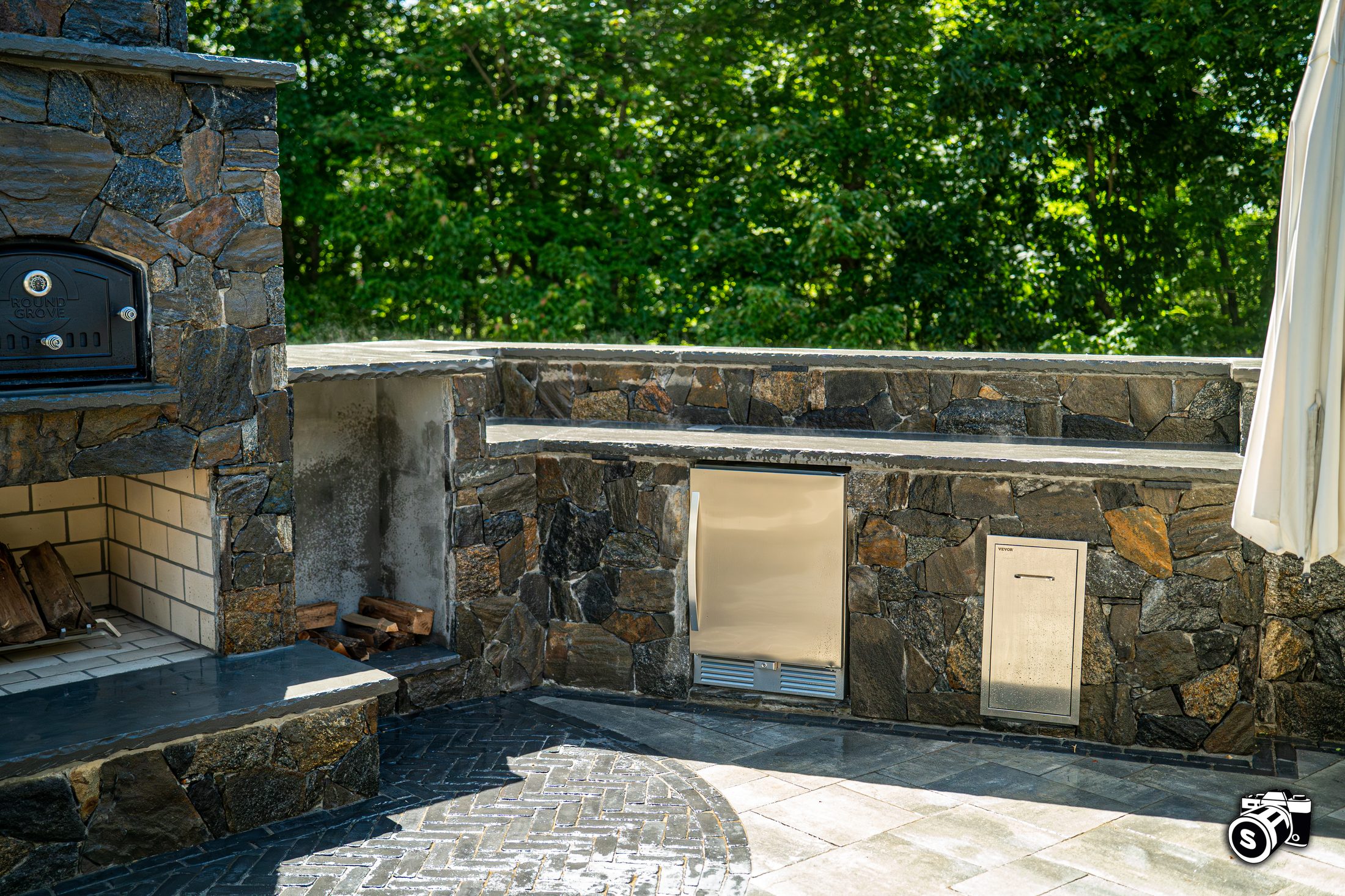 Stone outdoor kitchen with wood-fired pizza oven