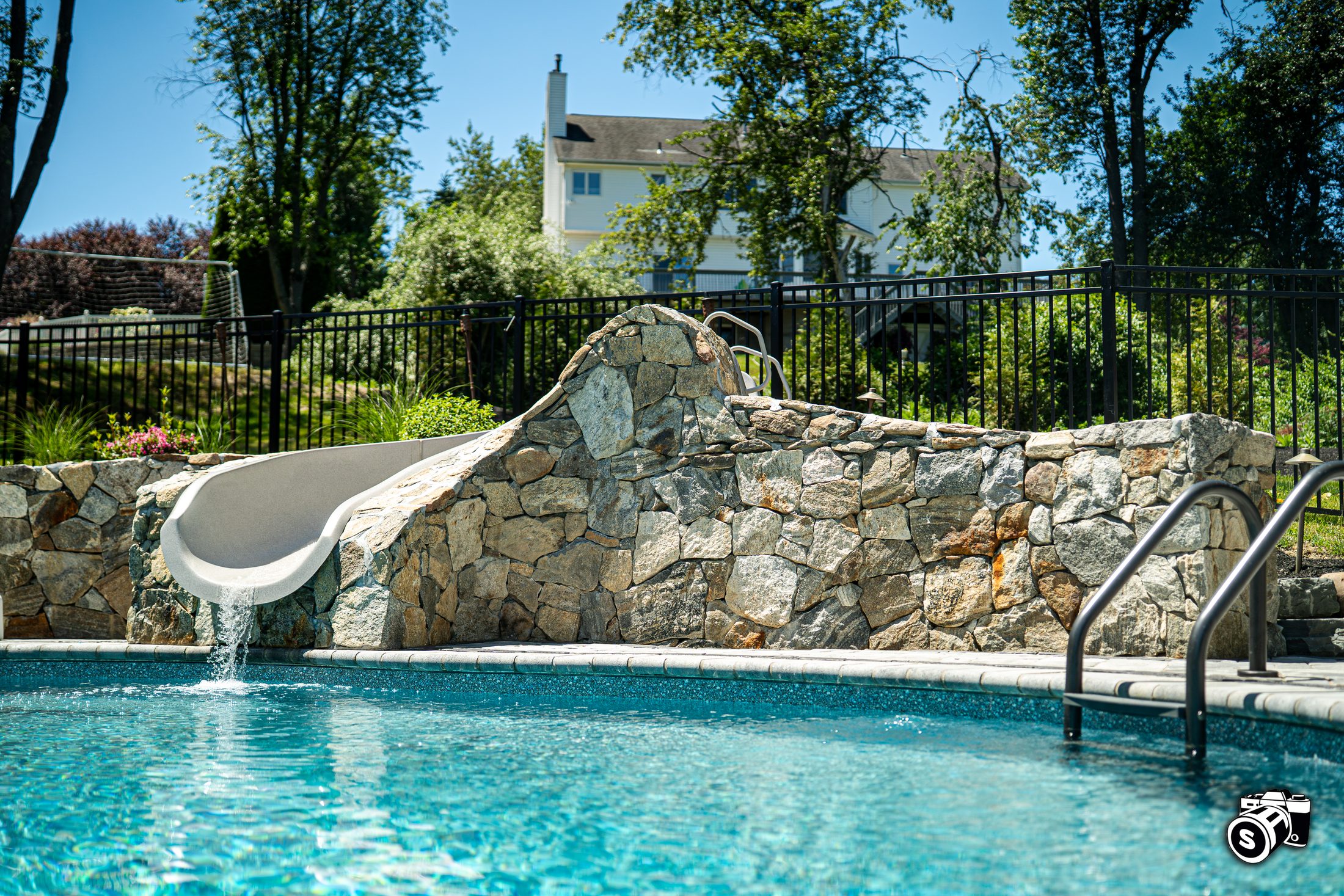 Stone-clad pool water slide