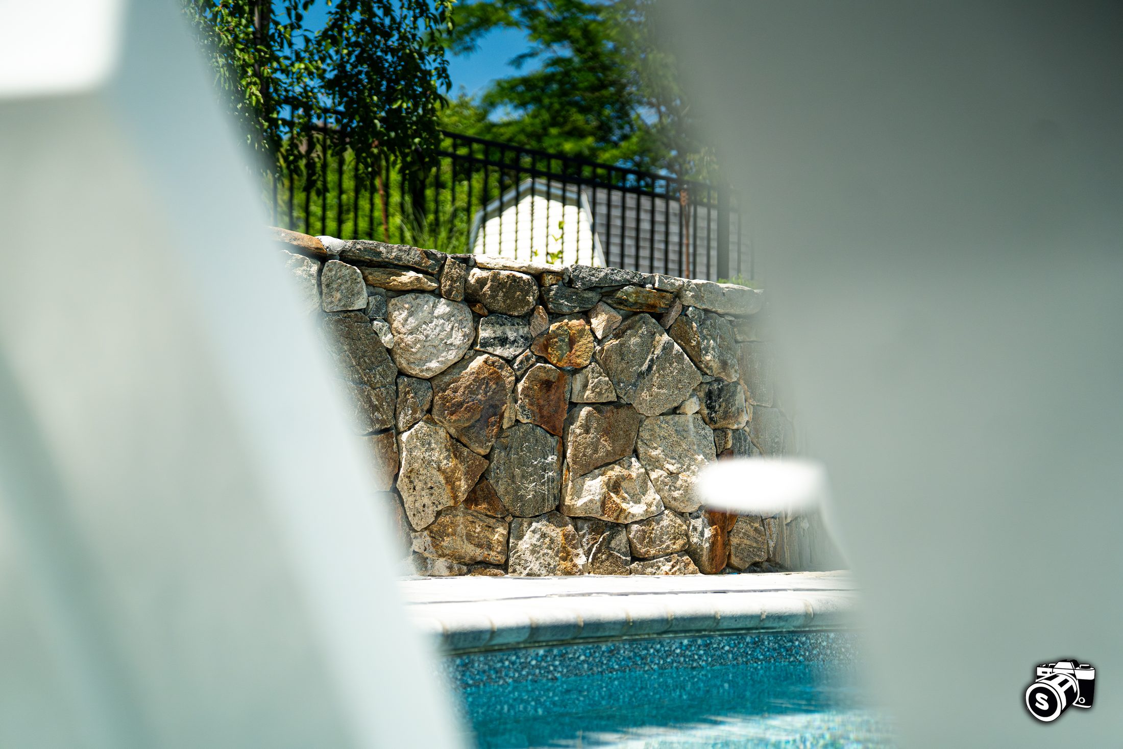 Stone veneer wall beside a pool