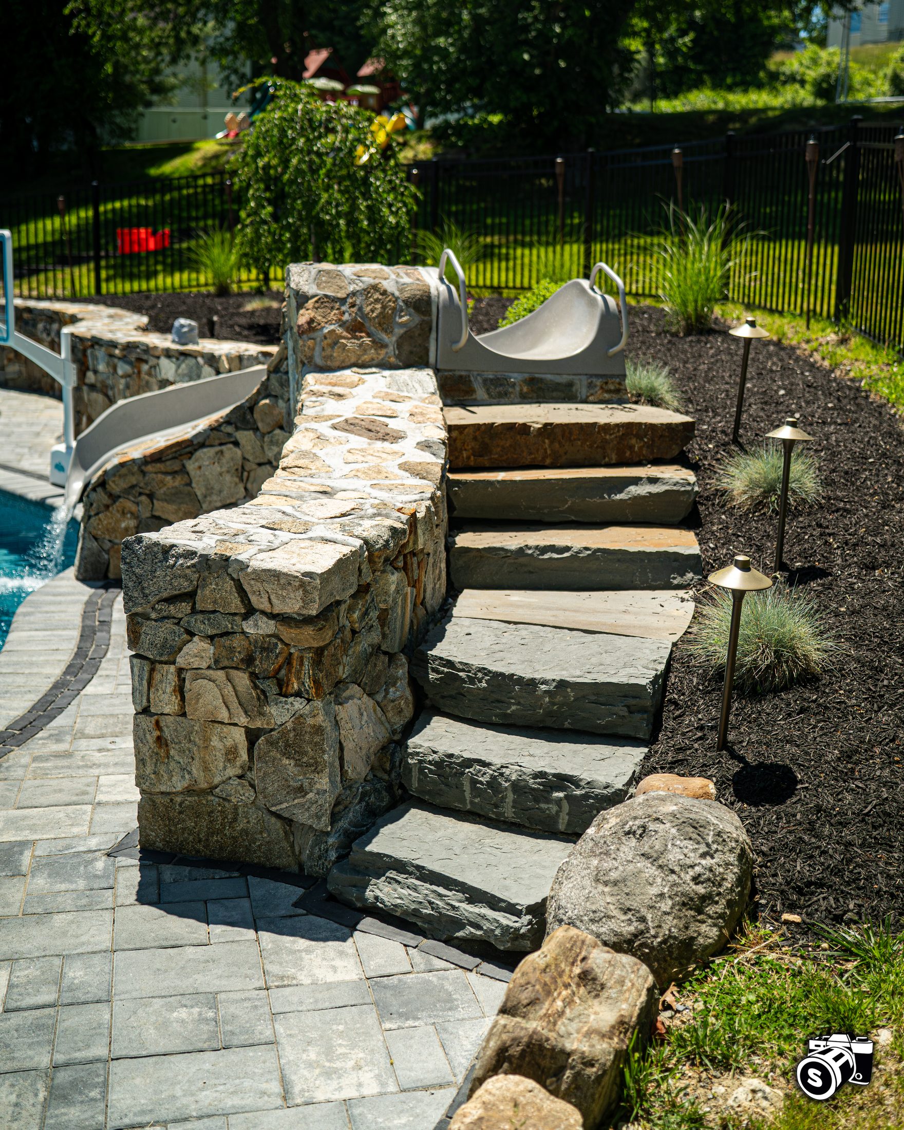 Stone steps beside a pool water slide